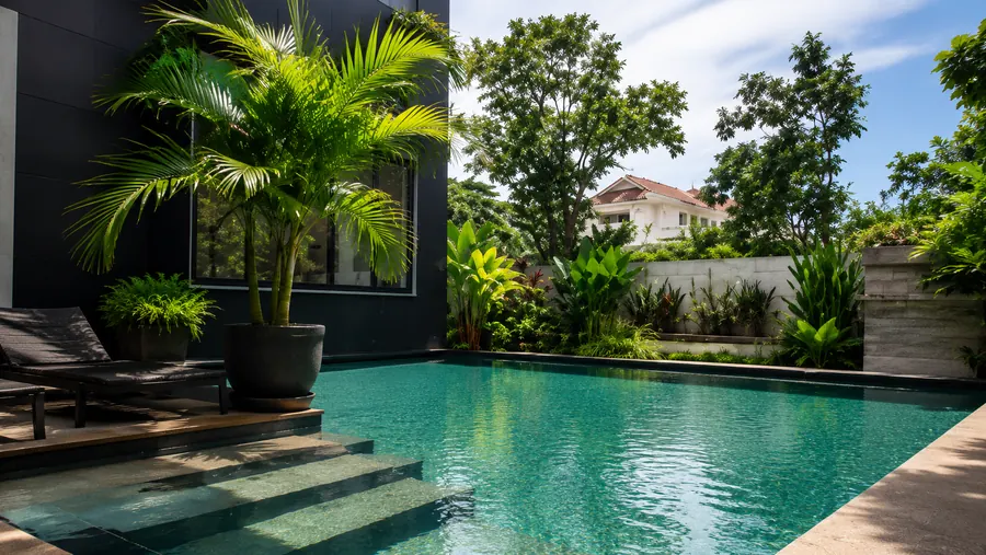 Turquoise outdoor pool surrounded by tropical palms